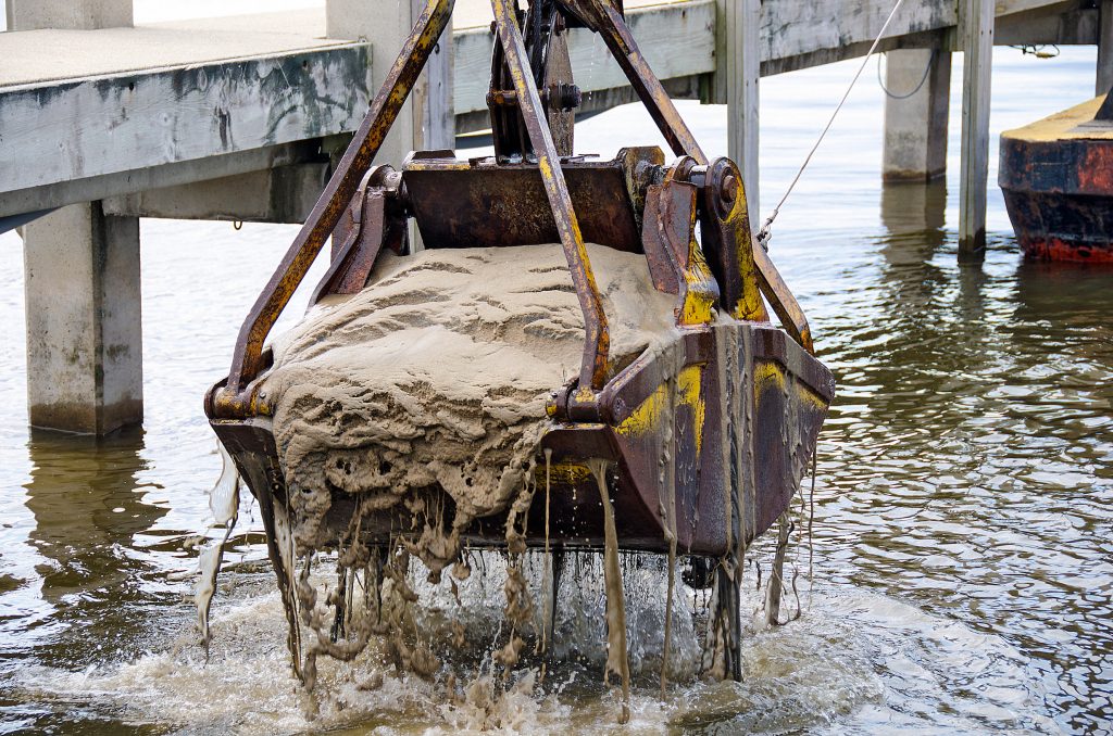 dredger bucket dredging lake bottom in marina